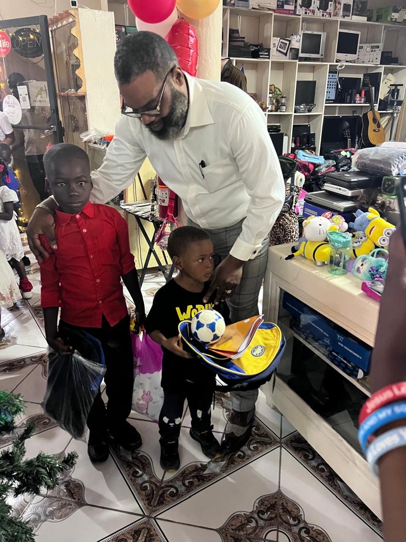 Two boys receiving a soccer ball and backpack during outreach
