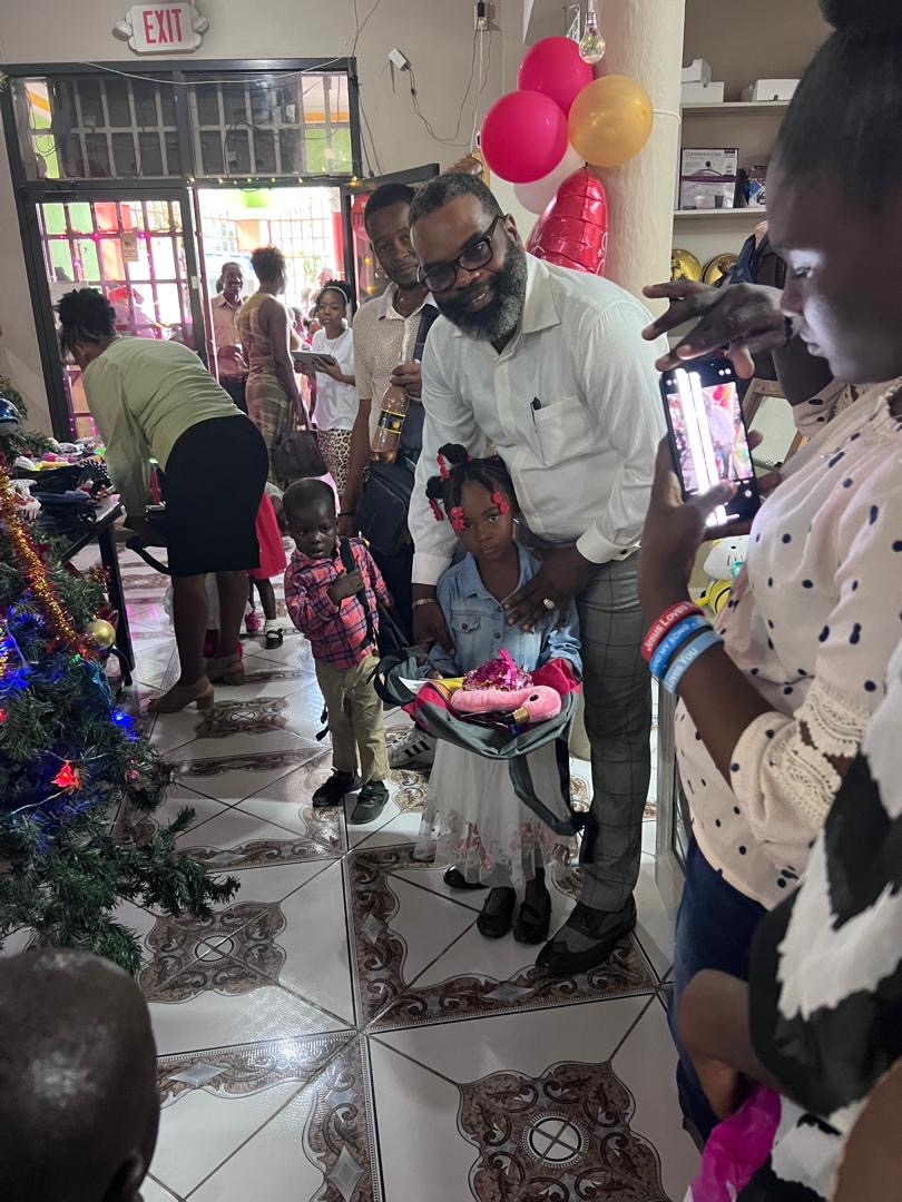 Pastor with a young girl and boy holding new backpacks