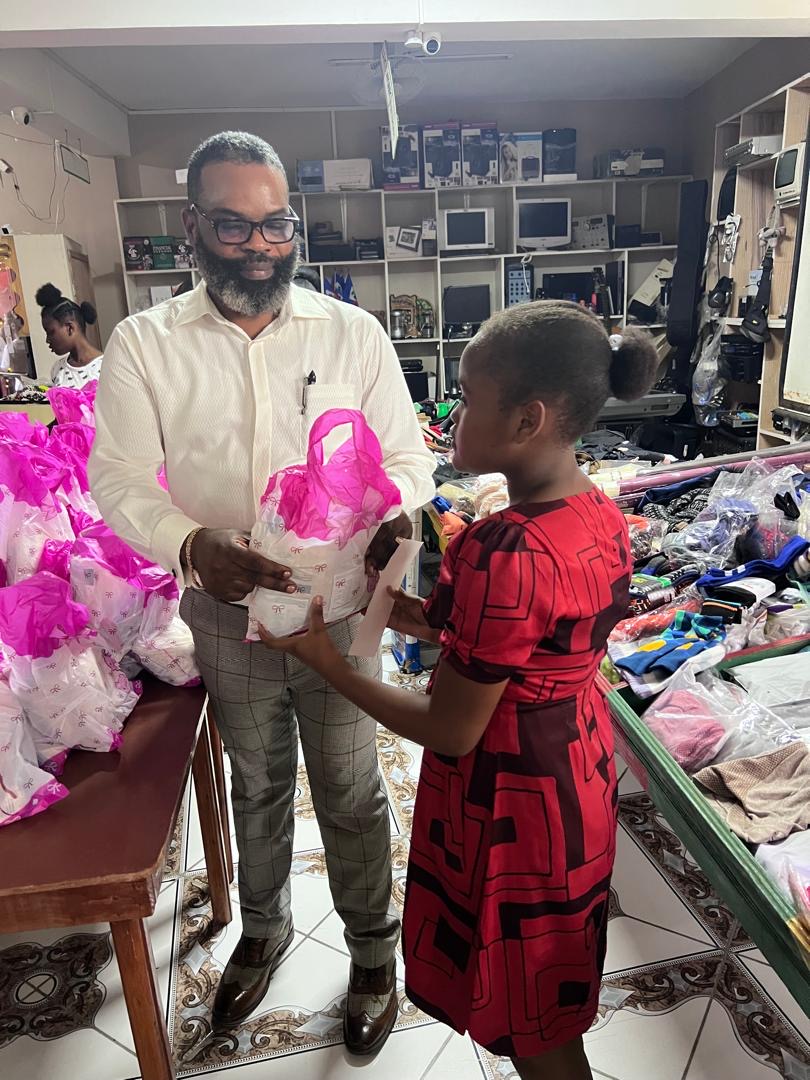 A girl receiving a wrapped gift from SCH leadership