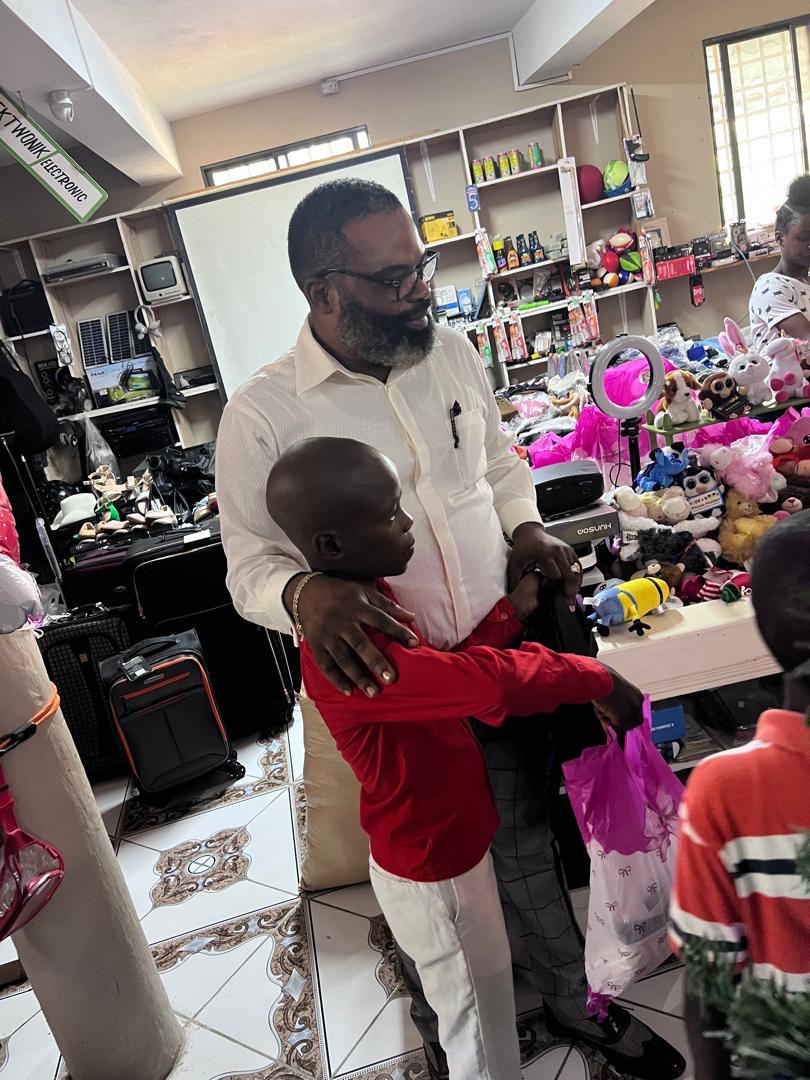 Boy in red shirt receiving his Christmas gift bag