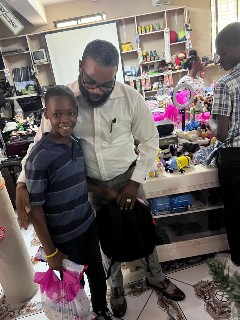 Smiling boy posing with the pastor at the gift event