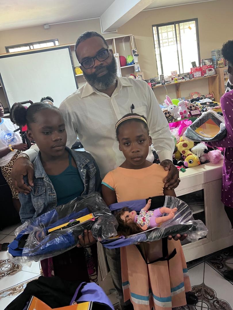 Two girls with dolls and supplies from the distribution