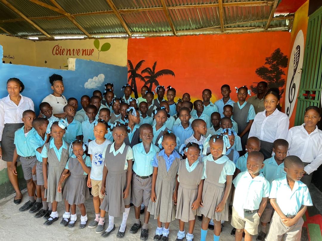 SCH primary school students gathered in uniform outside the schoolhouse