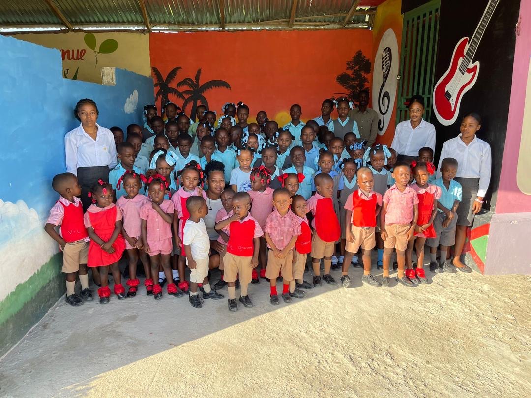 Full school photo with students in blue and red uniforms